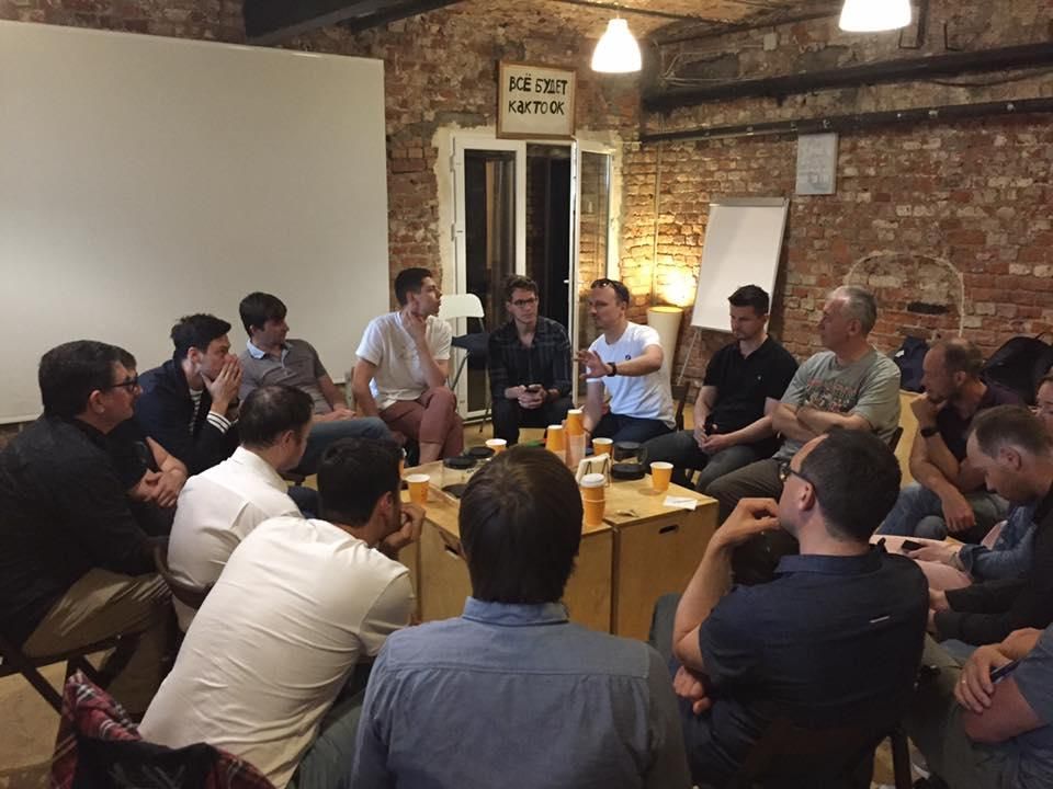 A circle of founders and mentors in a brick-walled room